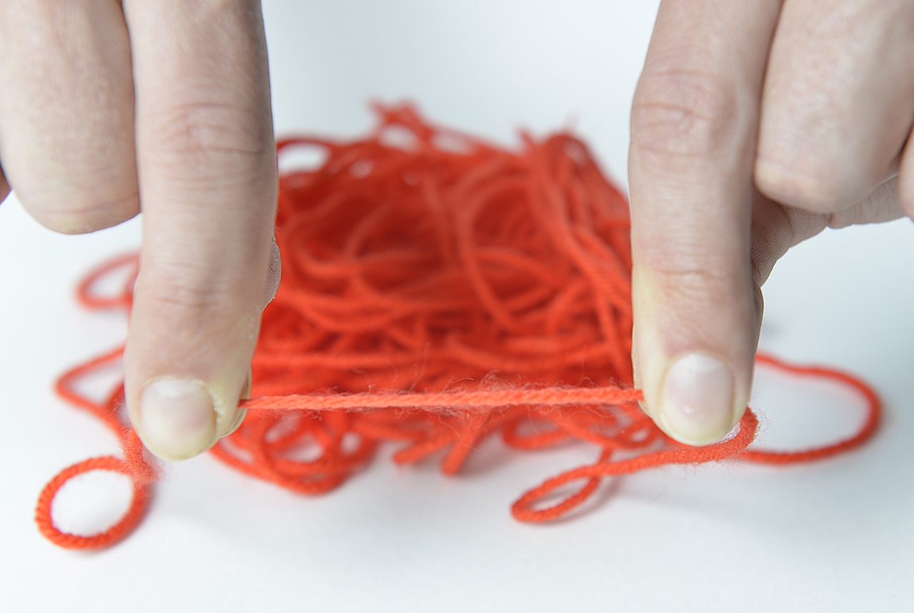 A tangled spool of yarn represents DNA, while the fingers holding the section represent the insulators just added by MU researchers to improve a scientific, screening tool. | Paige Blankenbuehler 
