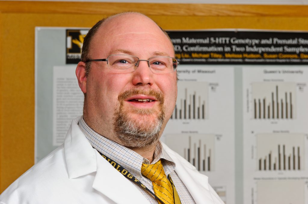 David Beversdorf in front of research poster. 