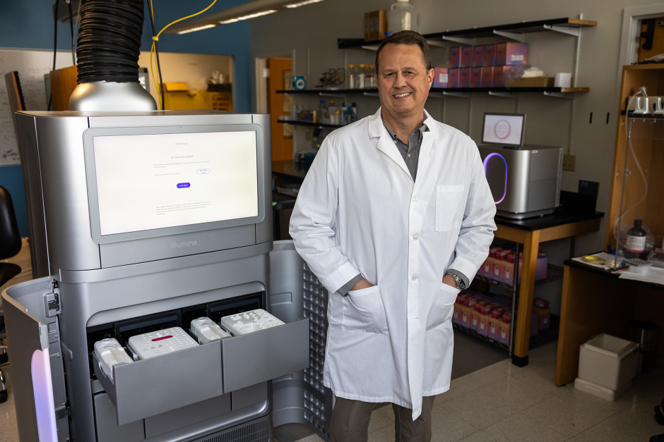 Nathan Bivens posing in front of equipment in his lab.