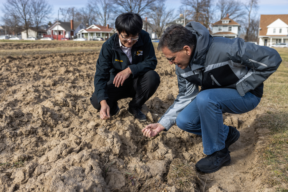 Researchers touching soil at Sanborn Field.